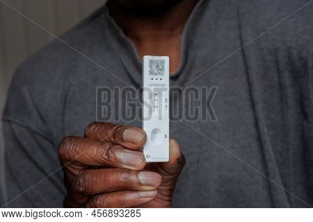 Person Of African Ethnicity Holding A Single Positive Covid-19 Rapid Home