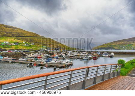 Boats Parked In The Bay, Among The Beautiful Mountains. Clouds, Fog. Faroe Islands. Denmark. Europe.