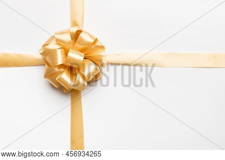 Top View Of Gold Ribbon Rolled And Yellowbow Isolated On Colored Background. Flat Lay With Copy Spac