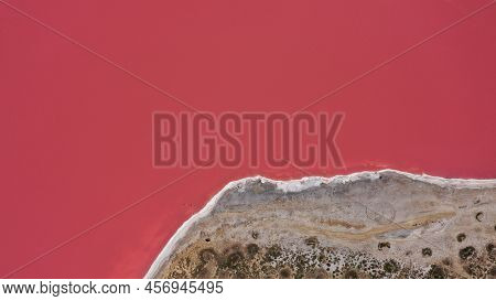 Flying Over A Pink Salt Lake. Salt Production Facilities Saline Evaporation Pond Fields In The Salty
