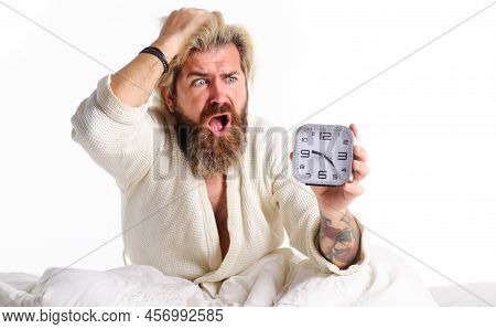 Overslept Bearded Man With Alarm Clock In Bed. Oversleeping, Late For Work. Deadline, Tardiness.
