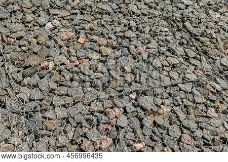 Granite Gravel Reinforcement Of Road Embankment Covered Wth Steel Mesh At Direct Sunlight - Full-fra