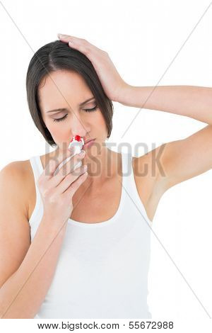 Casual young woman with bleeding nose standing over white background