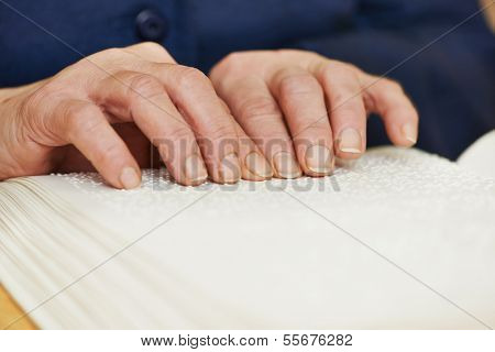 Blind or visually handicapped woman hands reading book written in Braille