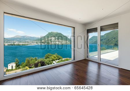 Interior, modern penthouse, empty living room with large windows
