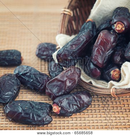 Dried date palm fruits or kurma, ramadan food which bamboo basket.