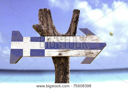 Greece wooden sign with a beach on background 