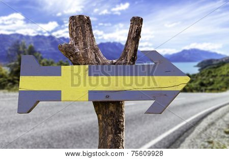 Sweden wooden sign with a landscape on background