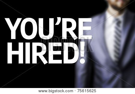 You're Hired! written on a board with a business man on background