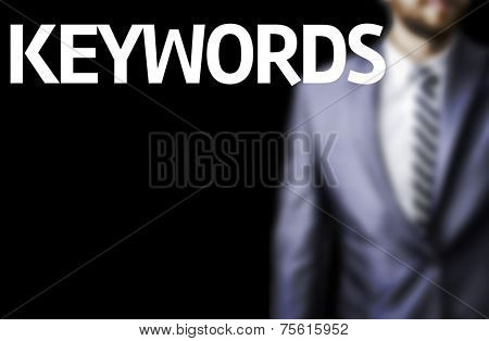 Keywords written on a board with a business man on background