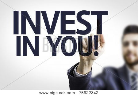 Business man pointing to transparent board with text: Invest in You