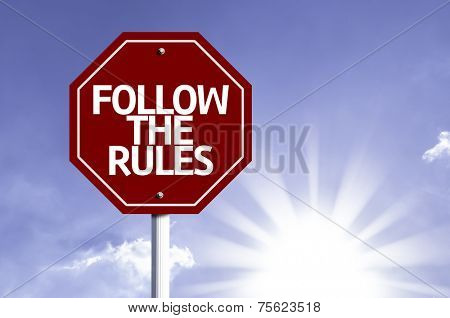 Follow the Rules written on red road sign with a sky on background