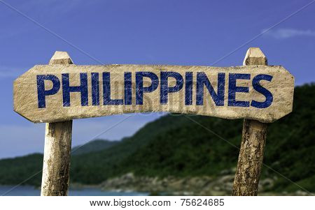 Philippines wooden sign with a beach on background