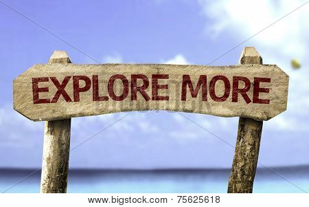 Explore More wooden sign with a beach on background