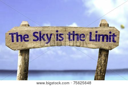 The Sky is The Limit wooden sign with a beach on background