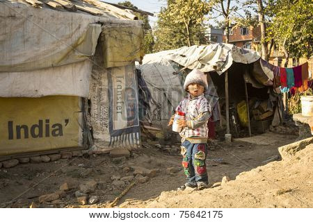 KATHMANDU, NEPAL - DEC 16, 2013: Unidentified poor child near their houses at slums in Tripureshwor district. Caste of untouchables in Nepal, is about 7 % of population.