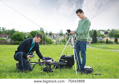 Young technicians working on UAV spy drone in park