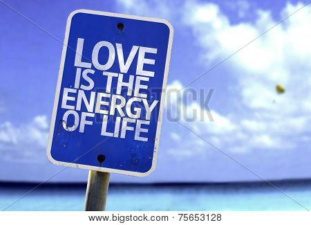 Love is The Energy of Life sign with a beach on background