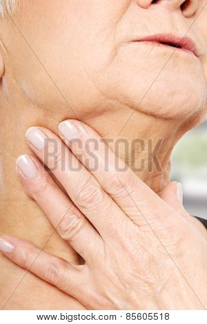 Close up on older woman's hand holding neck