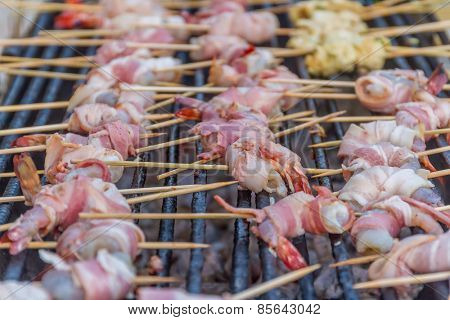 many prawns in bacon bbq sticks on grill, outdoor, summer bbq time