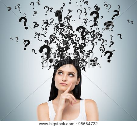 A Portrait Of A Beautiful Brunette With Questioning Expression And Question Marks Above Her Head.