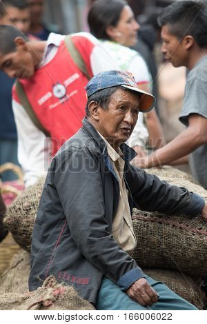 September 6, 2016 Silvia, Colombia: a man is sitting on a bag of potatoes in the produce market