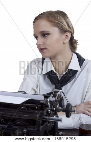 Young girl typist with an old typewriter on a white background