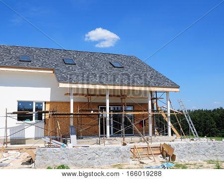 Construction and Renovation of the Rural House with Skylights Eaves Windows Fixing Facade Insulation Plastering and Painting House Facade Wall. Install Plastic Siding Soffits and Eaves Exterior.