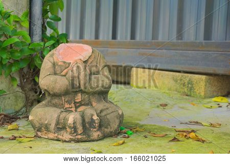 The doll without head left on the sidewalk near the base of the poles.