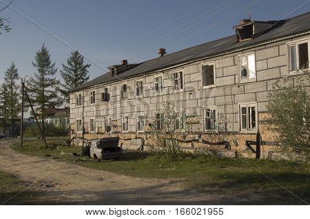 Ruined grey two-storeyed house in the north city