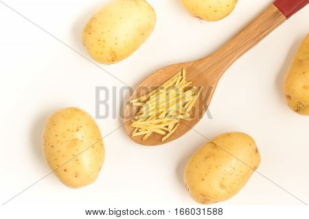 Potato Sticks into a spoon on white background