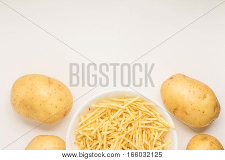 Potato Sticks into a bowl on white background