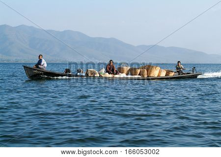Maing Thauk (lake Inle) Myanmar - 15 January 2010: People transporting goods on a canoe at lake Inle Myanmar