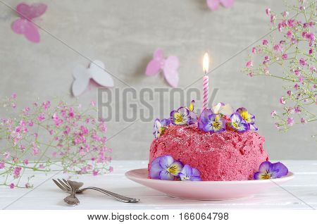 homemade birthday cake with pink buttercream and horned pansy