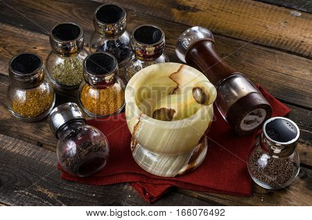 spices in Jar with mortar on a wodeen background
