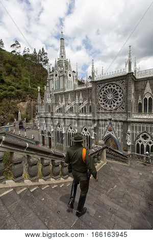 August 30, 2016 Las Lajas, Colombia: an armed soldier is descending towards the sanctuary on the outdoor stairs