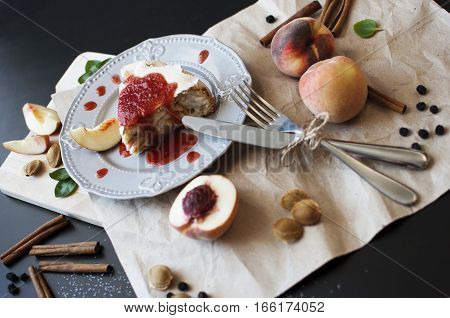 Piece of cake with jam and peaches on a dark wooden table. Pie Baking Cinnamon Peach Jam