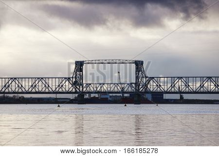 white cumulus clouds pass bridge over the Northern Dvina River