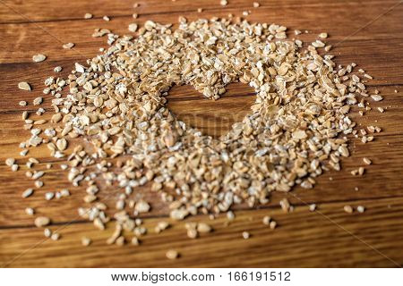 Heart painted in oatmeal on wooden background. Healthy food concept