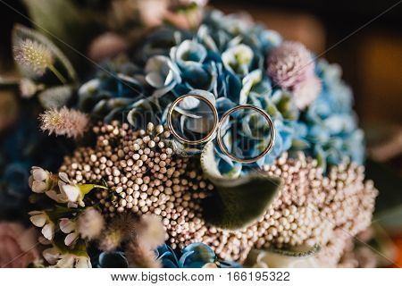 Wedding rings on wedding bouquet from the top view
