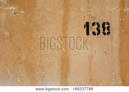 House number 138 sprayed on an old wall
