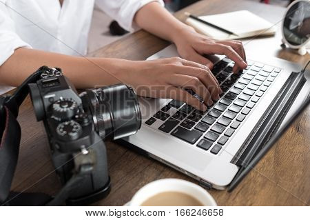 Photographer editing photos on laptop. Studio work, photo service concept. Workplace