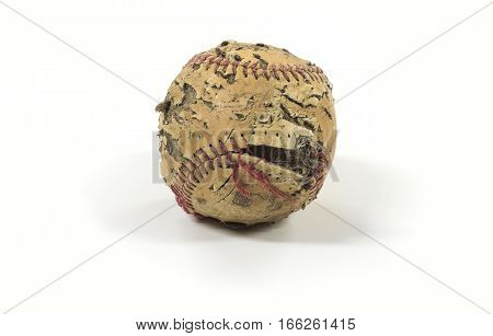 An old baseball that has seen better days. Torn stitches Discolored leather ripped and torn sitting on a clean white background.