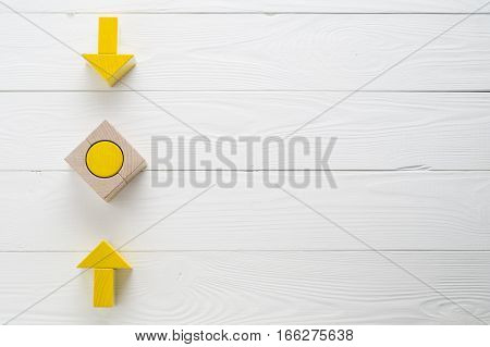 Symbol of goal and objective. Two wooden arrows converge towards the center target top view. Arrows pointing to the object flat lay copy space. Concept of the implementation of the planned success.