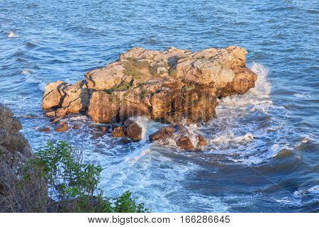 little rocky island in blue sea water
