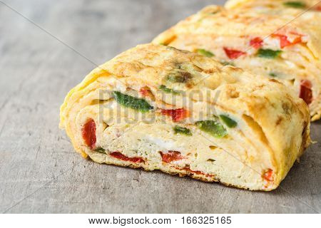 Traditional tamagoyaki Japanese omelette on wooden background