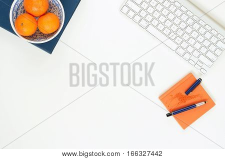 Minimal elegant desk composition flat lay with tangerine and keyboard