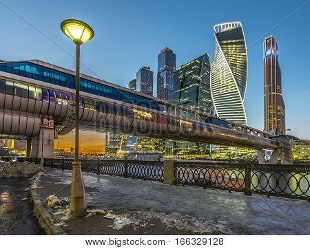 Moscow Russia - November 20 2016: Pedestrian bridge Bagration on the background of Moscow city from the embankment of Taras Shevchenko in the winter at dusk.