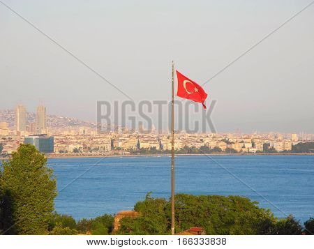 Turkish flag over Bosphorus on the background of the cityscape of Istanbul.