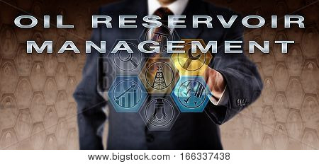 Male company manager in blue business suit pushing OIL RESERVOIR MANAGEMENT on an interactive virtual computer screen. Oil and gas industrial technology concept for managing well development.